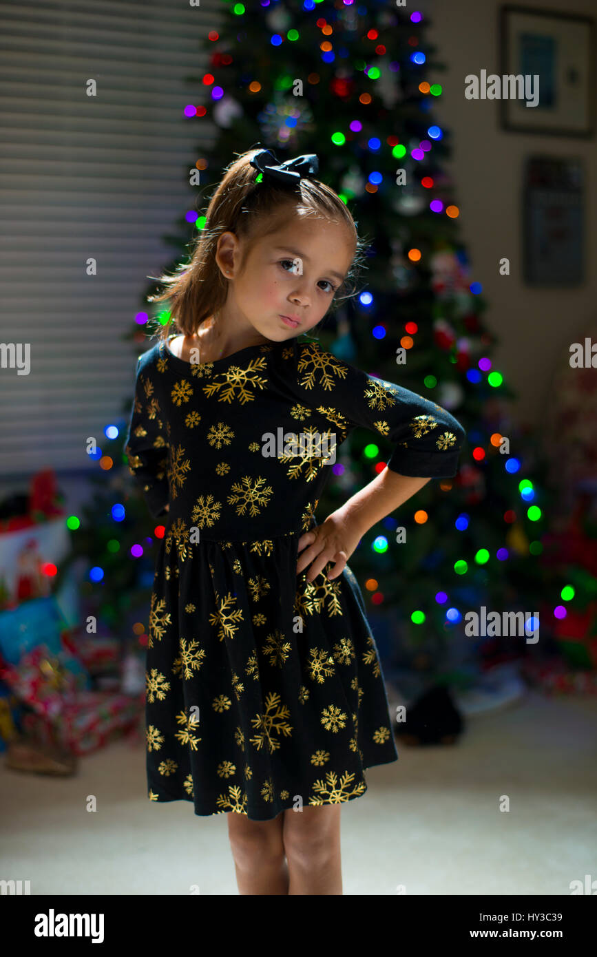 little girl smiling posing by Christmas tree Stock Photo - Alamy