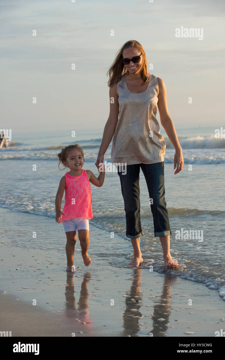 mom and daughter walking in the water Stock Photo