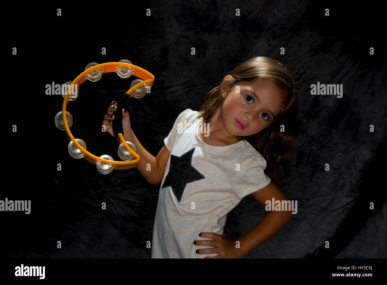 young girl with instrument  holding tambourine Stock Photo