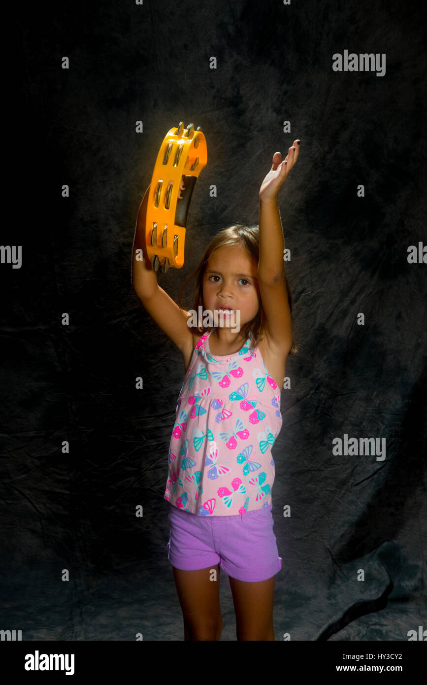 young girl with instrument  holding tambourine Stock Photo