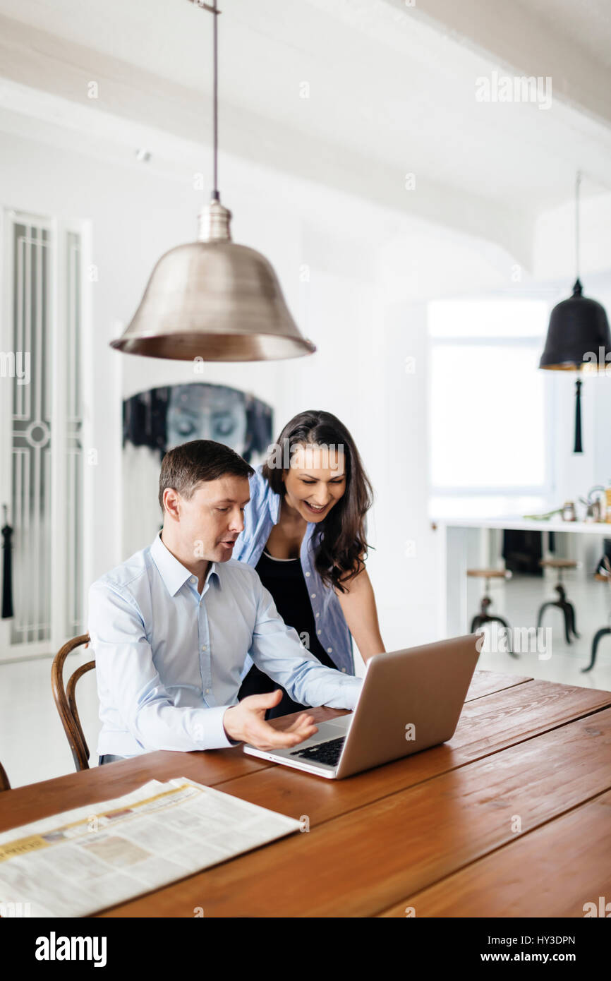 Germany, People laughing at something they see on computer display Stock Photo