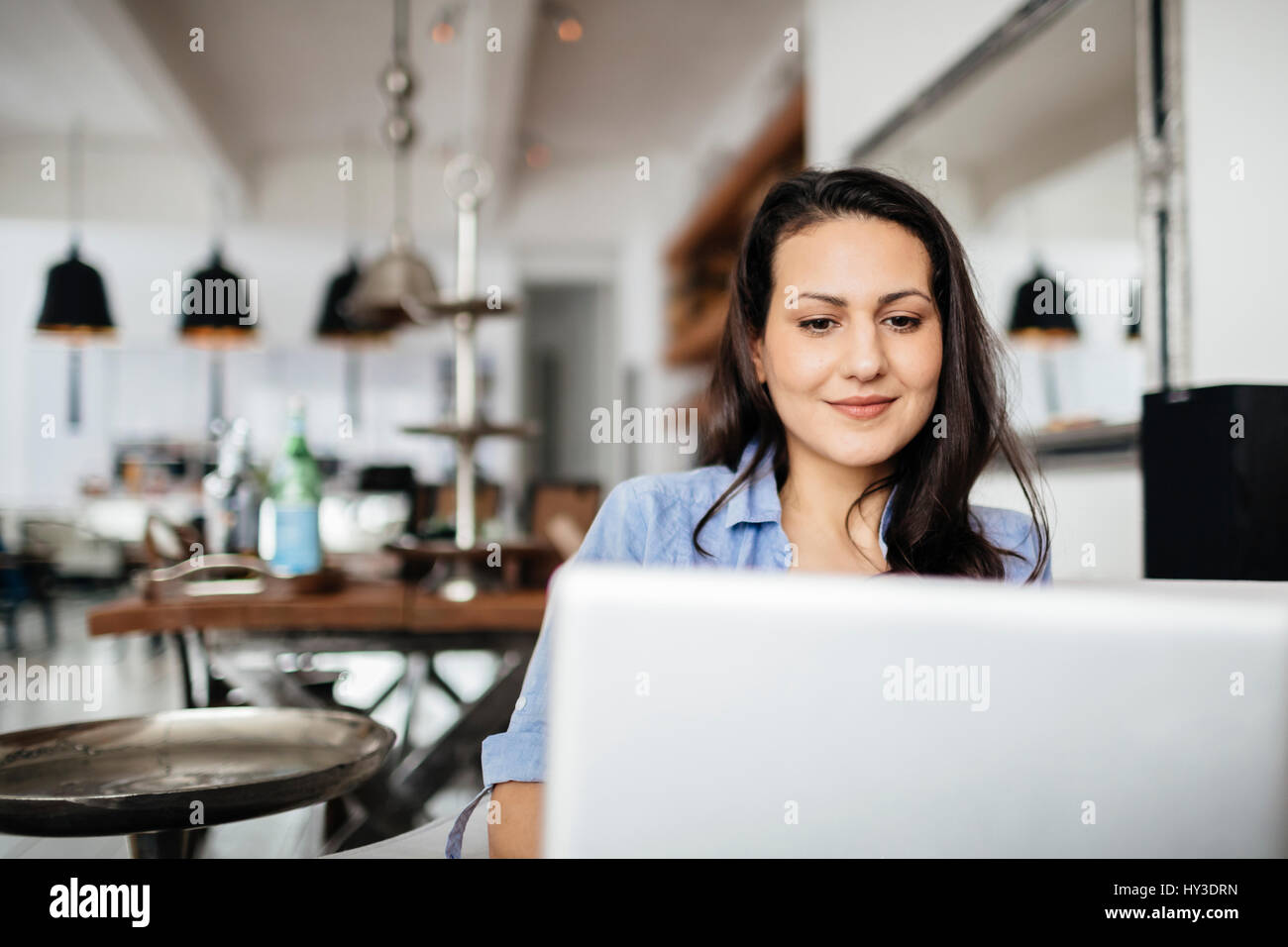 Germany, Pleased woman using computer Stock Photo