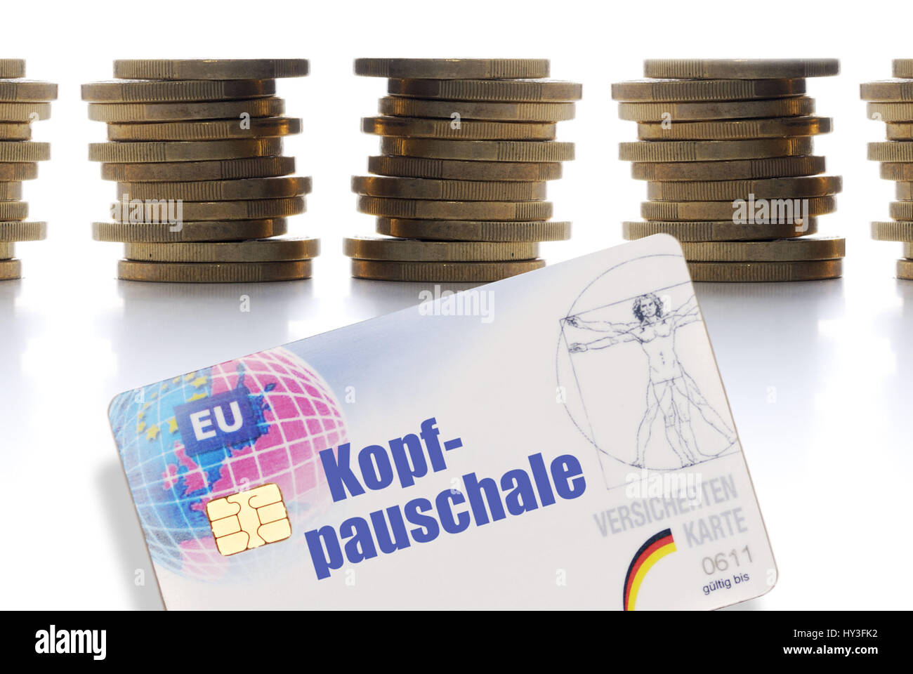 Insured map with the label Head-all-inclusive before stacked eurocoins, Versichertenkarte mit der Aufschrift Kopfpauschale vor gestapelten Euromünzen Stock Photo