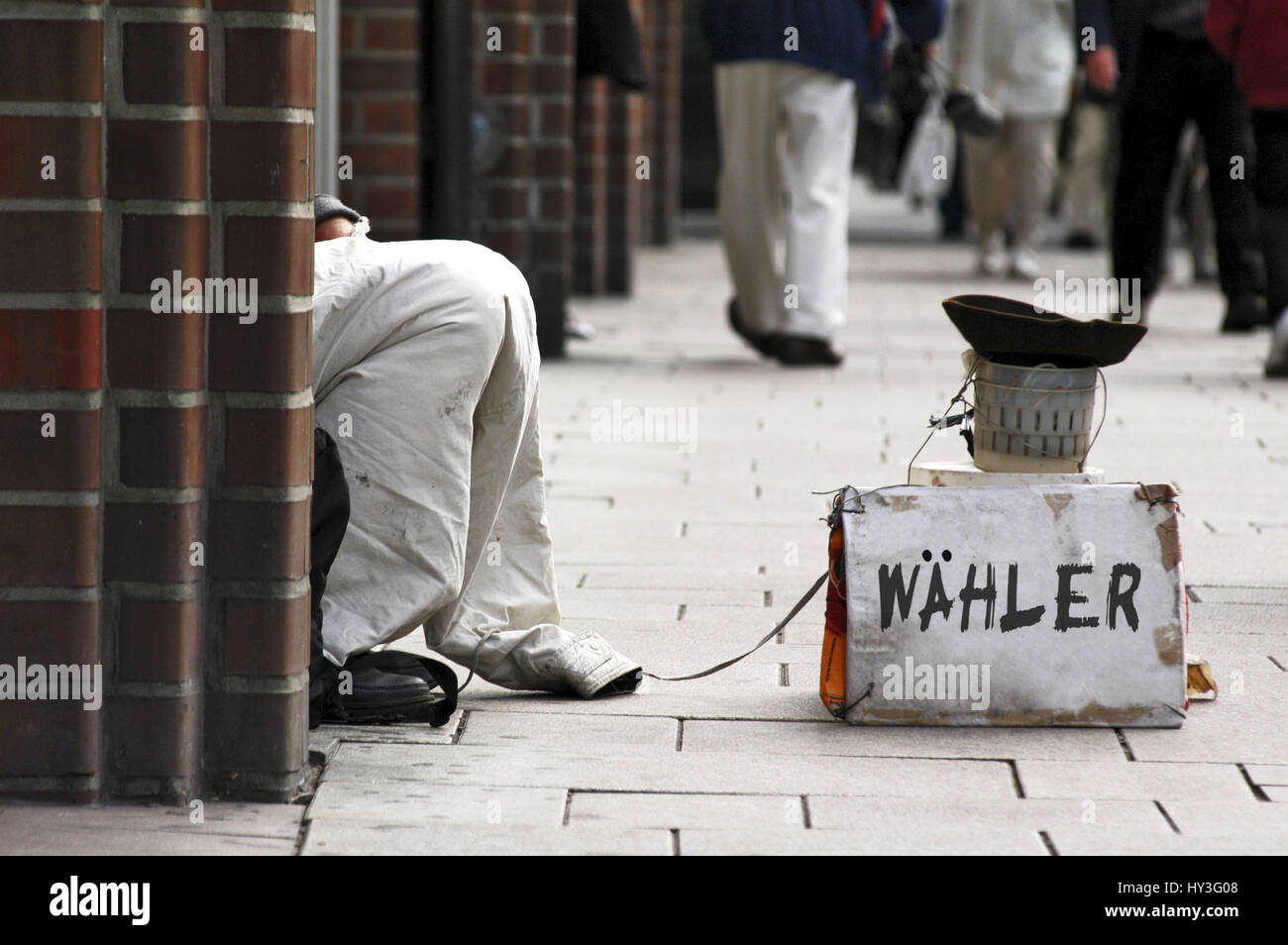 Beggar in the shopping street with sign Voter Bildmontage, Bettler in der Einkaufsstraße mit Schild Wähler (Bildmontage) Stock Photo