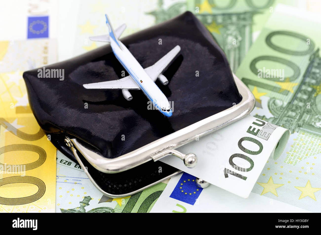 Miniature airplane on a change purse, symbolic photo aerial transfer tax, Miniaturflugzeug auf einer Geldbörse, Symbolfoto Luftverkehrssteuer Stock Photo