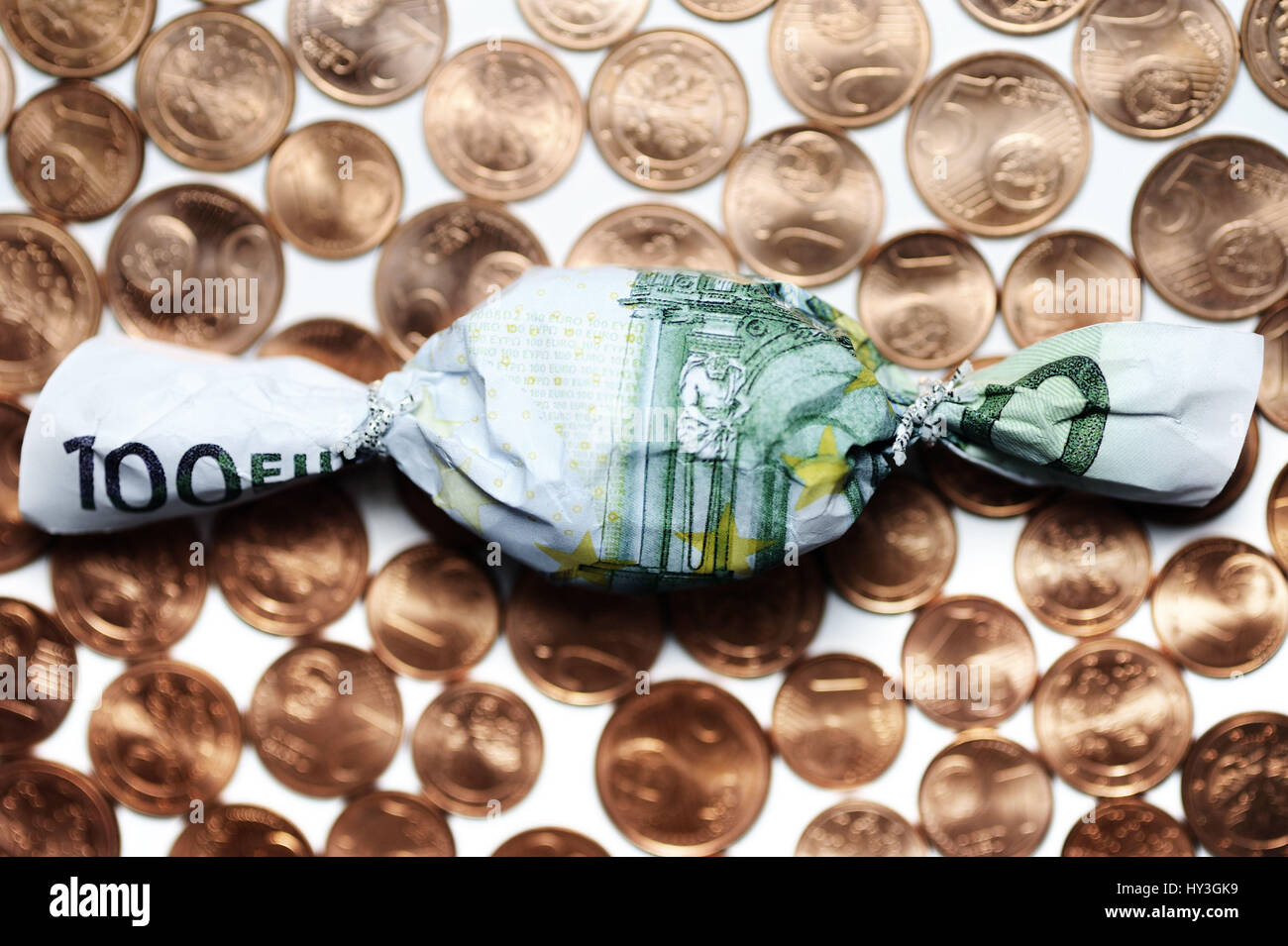 Sweet in euro-light hundred muffledly on cent coins, bonus payments, Bonbon in Hundert-Euro-Schein eingewickelt auf Cent-Münzen, Bonuszahlungen Stock Photo