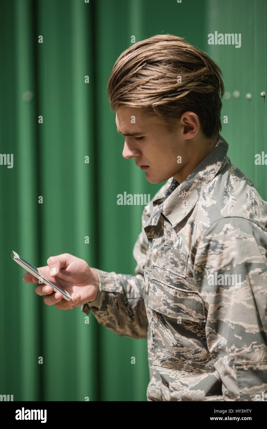 Military soldier using mobile phone in boot camp Stock Photo