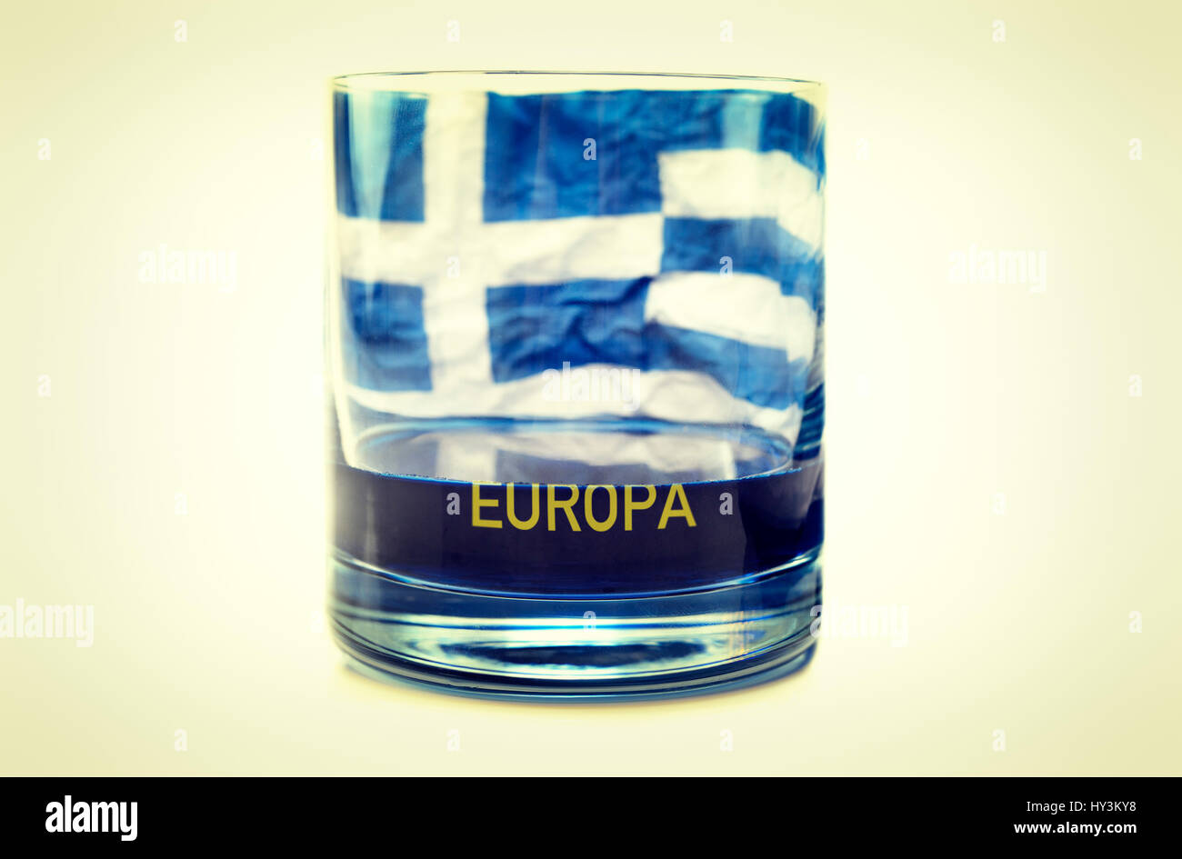 Half-empty glass with Greek flag, symbolic photo debt quarrel, Halbleeres Glas mit griechischer Fahne, Symbolfoto Schuldenstreit Stock Photo