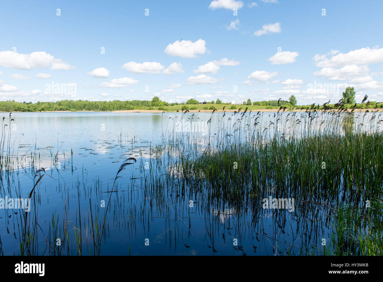 White clouds on the blue sky over blue lake with reflections Stock ...