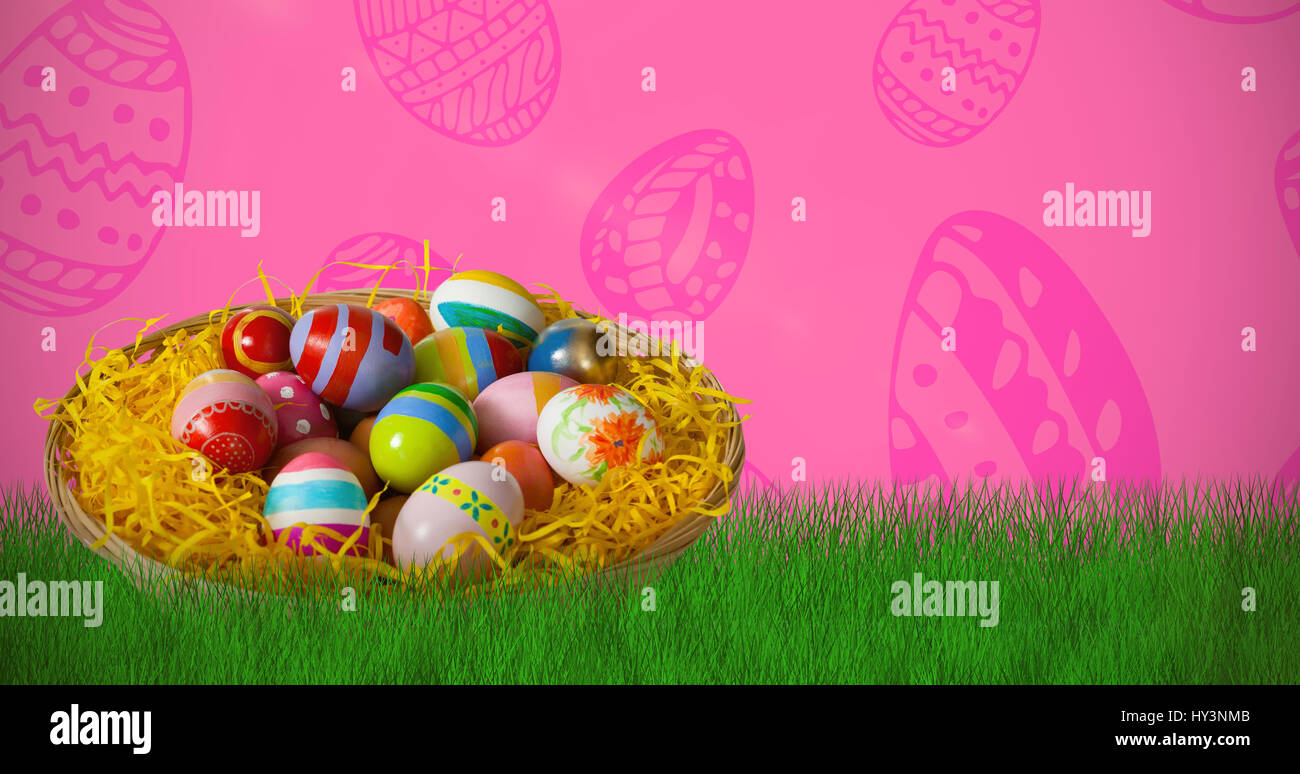 Multi colored easter eggs in wicker basket against pink background ...