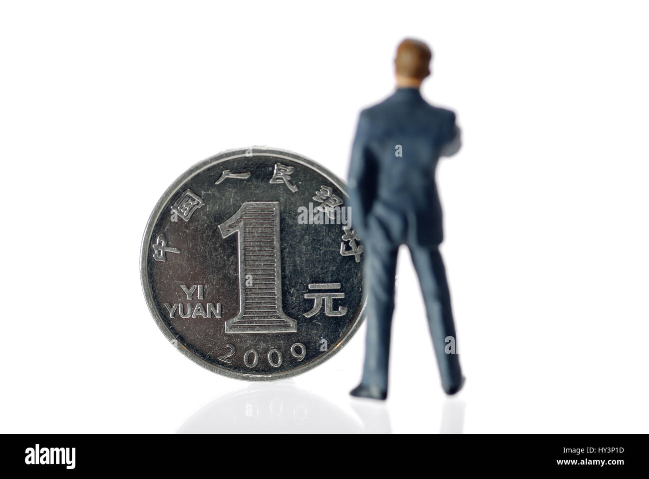 Miniature figure of a businessman before an one-yuan coin Chinese currency, Miniaturfigur eines Geschäftsmannes vor einer Ein-Yuan-Münze (chinesische  Stock Photo
