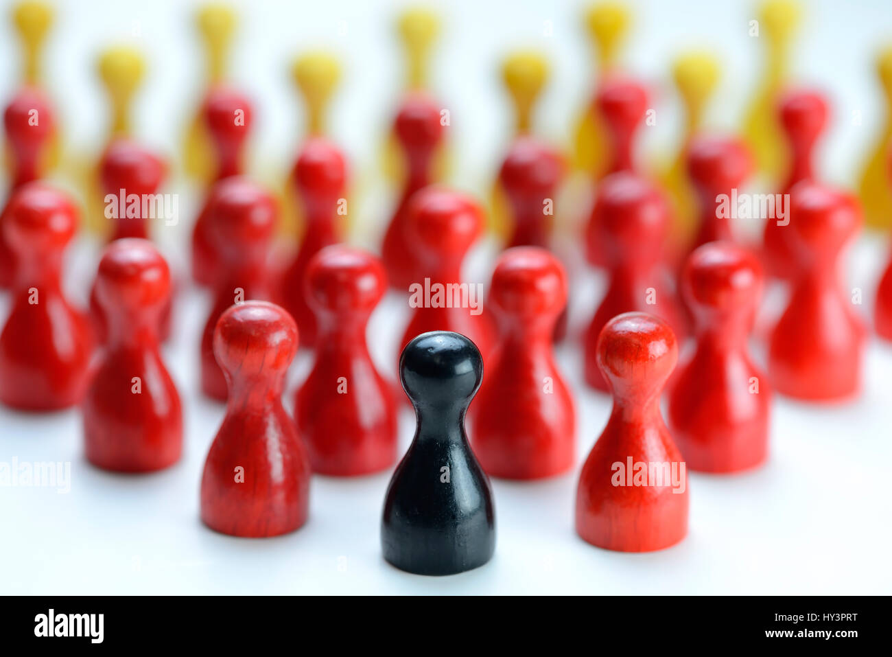 Black play figure before many red and yellow figures, symbolic photo for populism in Germany, Schwarze Spielfigur vor vielen roten und gelben Figuren, Stock Photo