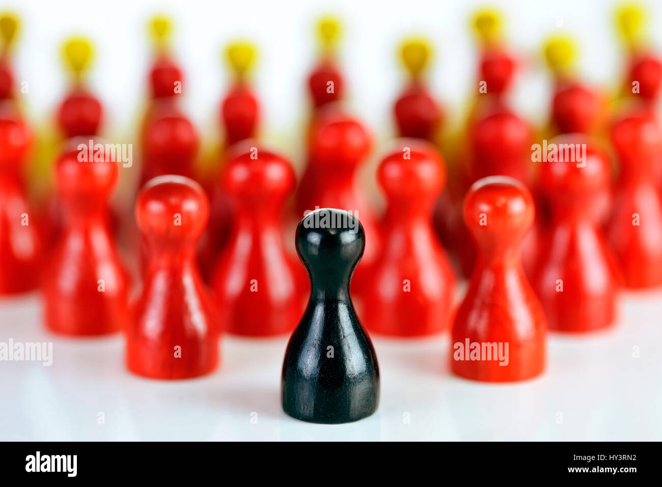 Black play figure before many red and yellow figures, symbolic photo for populism in Germany, Schwarze Spielfigur vor vielen roten und gelben Figuren, Stock Photo