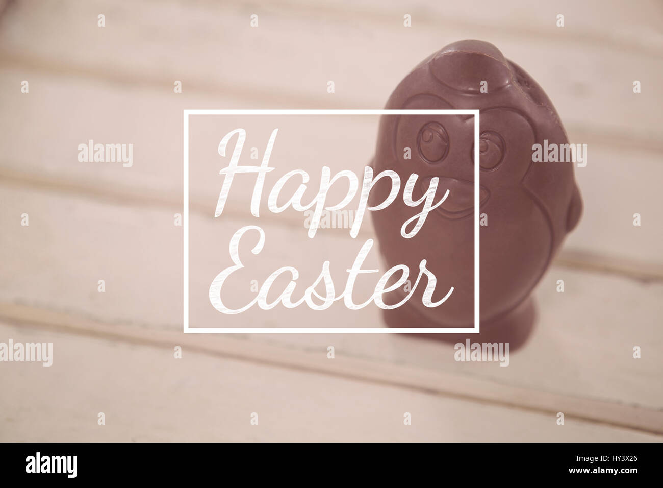 happy easter against chocolate easter egg on wooden plank Stock Photo