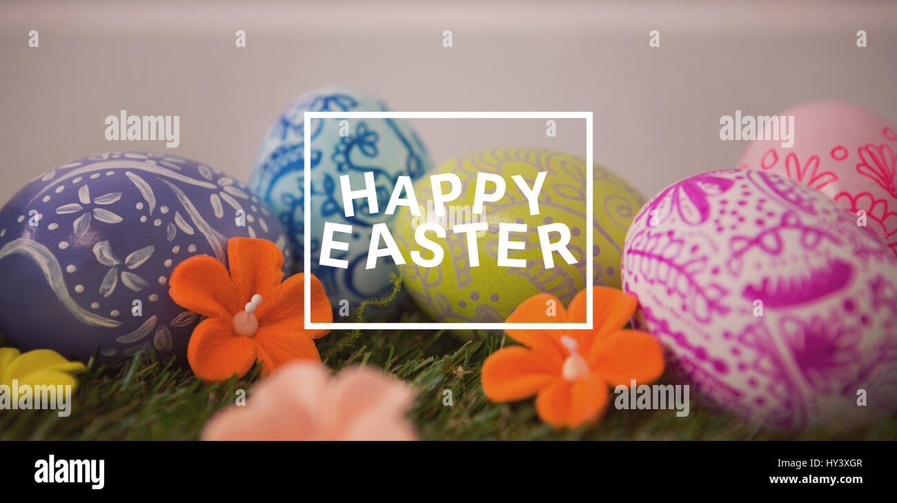 Easter greeting against painted easter egg on grass Stock Photo