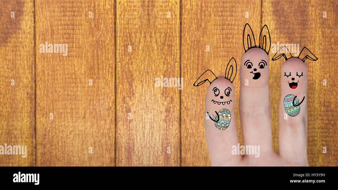 Digitally generated image of fingers representing Easter bunny against wooden background Stock Photo