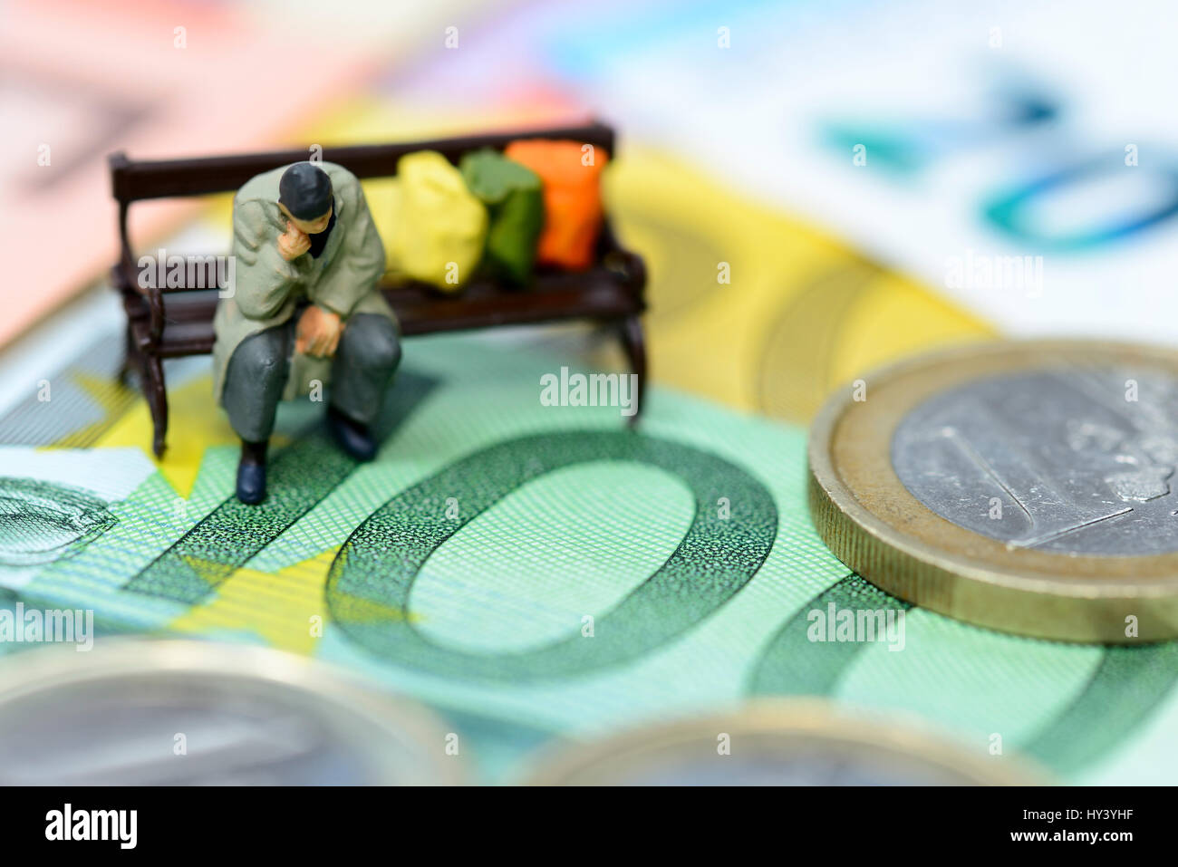 Miniature figure of a homeless on euronotes, symbolic photo basic income, Miniaturfigur eines Obdachlosen auf Euroscheinen, Symbolfoto Grundeinkommen Stock Photo