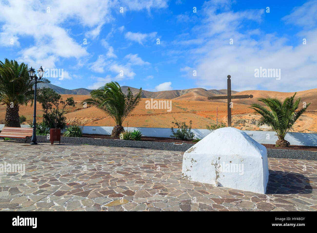Palm trees on village square in volcanic mountain landscape of Fuerteventura island, Spain Stock Photo