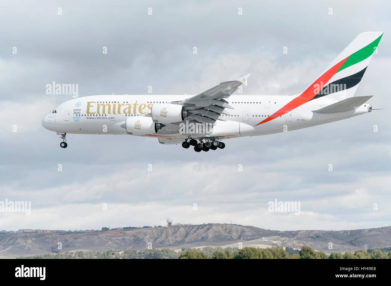 Plane Airbus A380, of Emirates airline, is landing in Madrid - Barajas, Adolfo Suarez airport. It's the world's largest passenger airliner. Clouds. Stock Photo