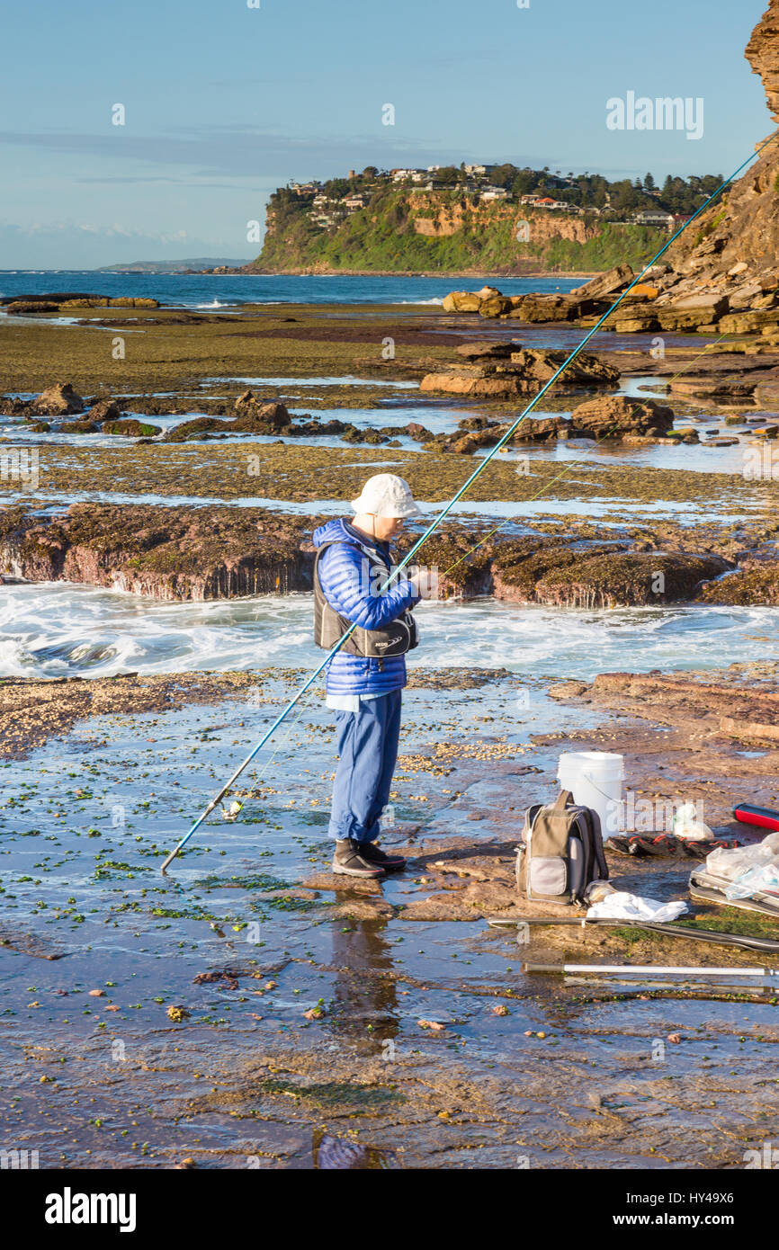 Asian man Rock fishing at Bilgola beach in Australia, wearing a life jacket  as many rock fisherman have lost their lives recently,Australia Stock Photo  - Alamy