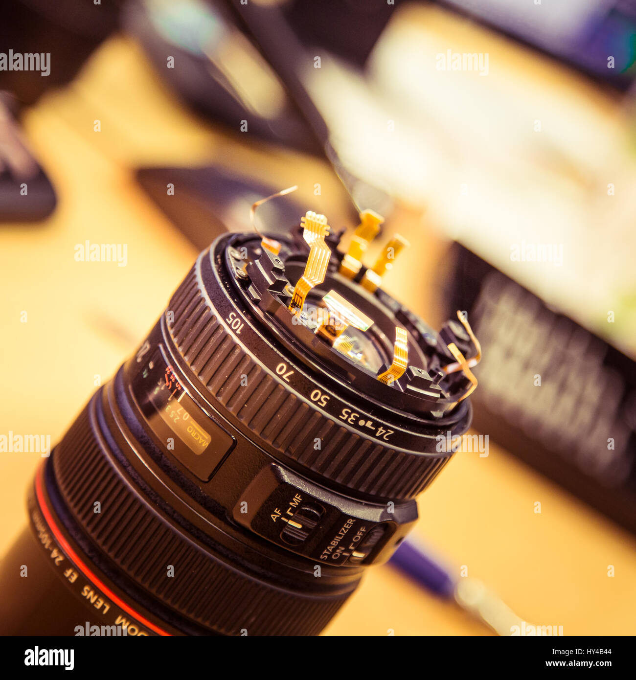A man fixing photo camera lens on an office table Stock Photo - Alamy