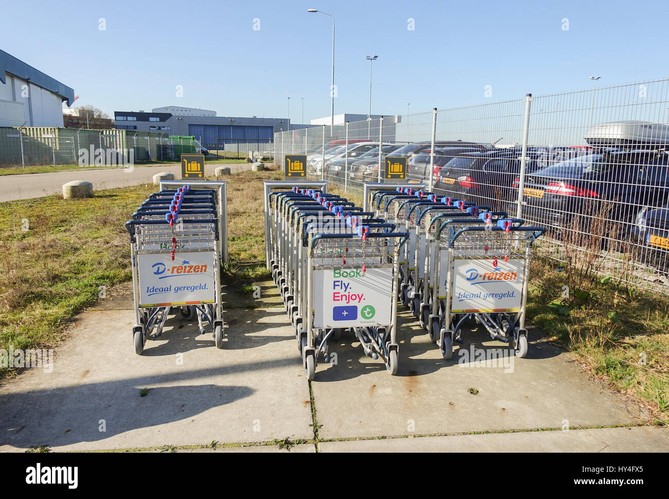 Row of Baggage carts outside at parking, Eindhoven Airport, Netherlands, Holland, travel. Stock Photo