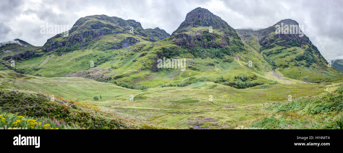 Glen Coe in the Scottish Highlands. This panorama shows the mountains known as The Three Sisters: Faith, Hope, and Charity. Stock Photo