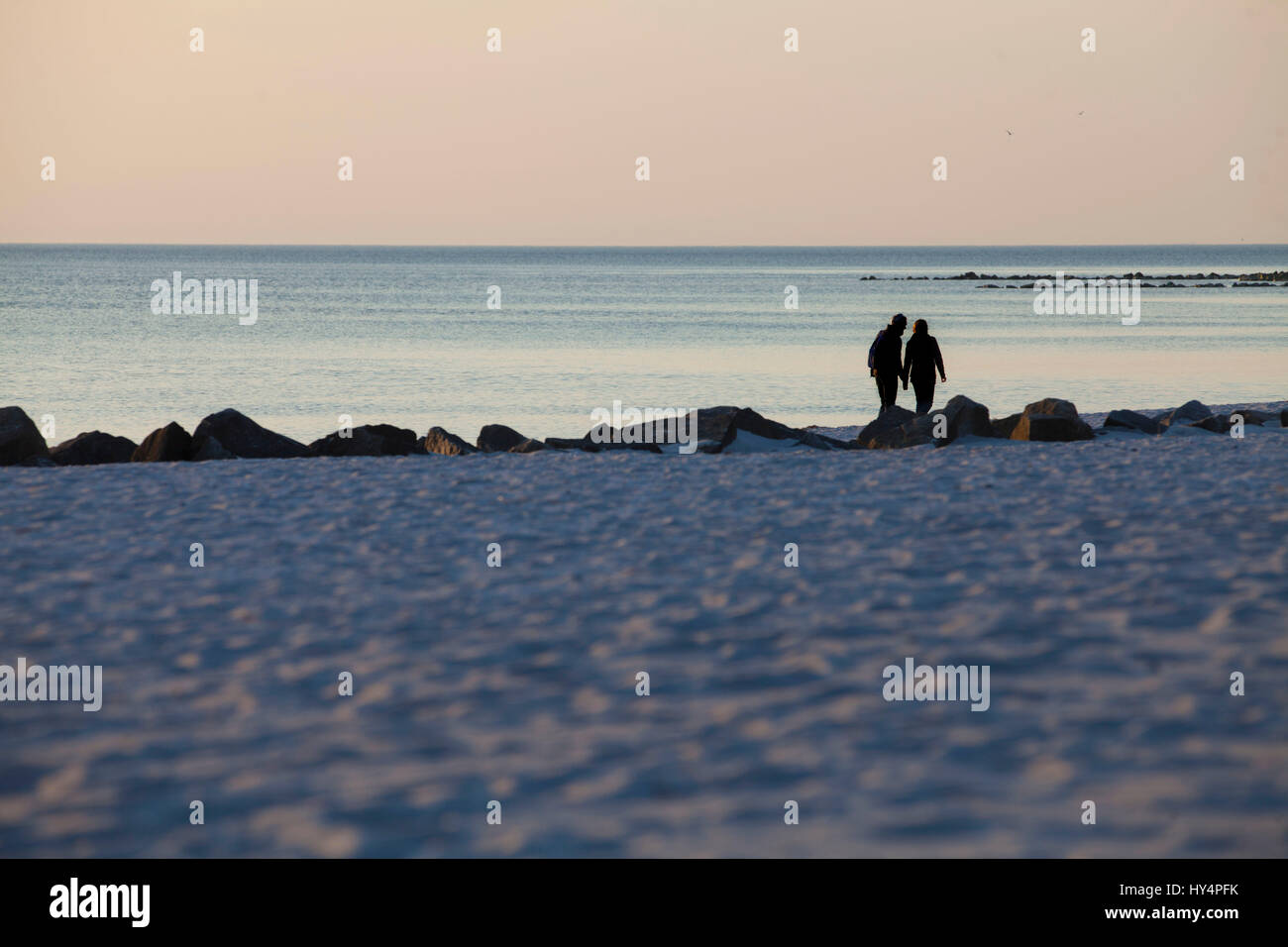 Two people walk along the beach Stock Photo - Alamy