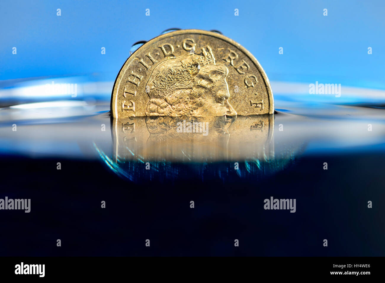 British one-pound coin in the water, low pound course, Britische Ein-Pfund-Muenze im Wasser, niedriger Pfund-Kurs Stock Photo
