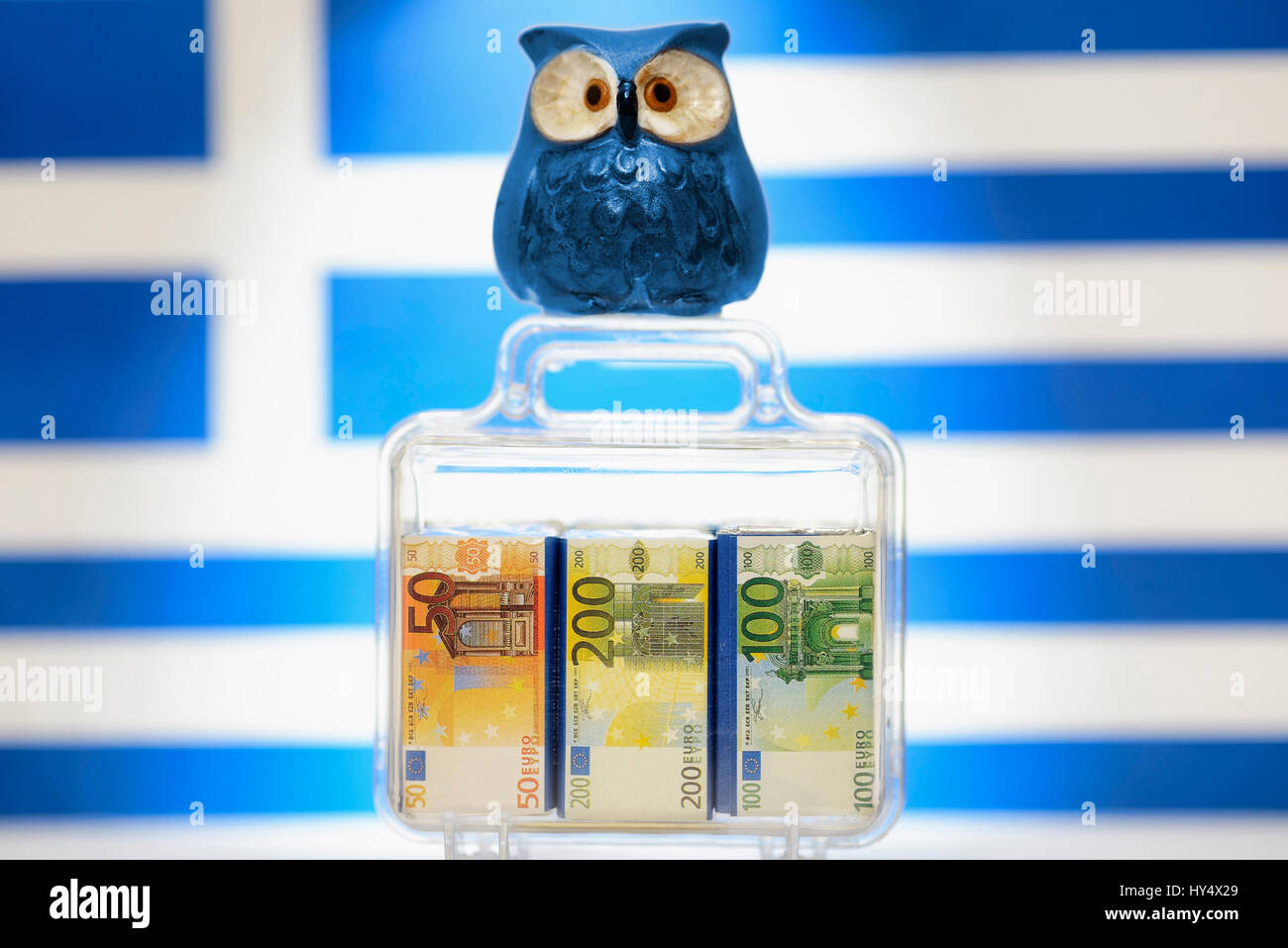 Owl on monetary suitcase before Greece flag, EU facilities to Greece, Eule auf Geldkoffer vor Griechenlandfahne, EU-Hilfen fuer Griechenland Stock Photo