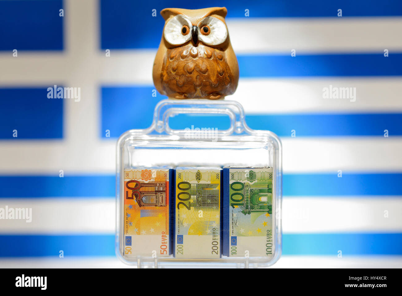 Owl on monetary suitcase before Greece flag, EU facilities to Greece, Eule auf Geldkoffer vor Griechenlandfahne, EU-Hilfen fuer Griechenland Stock Photo
