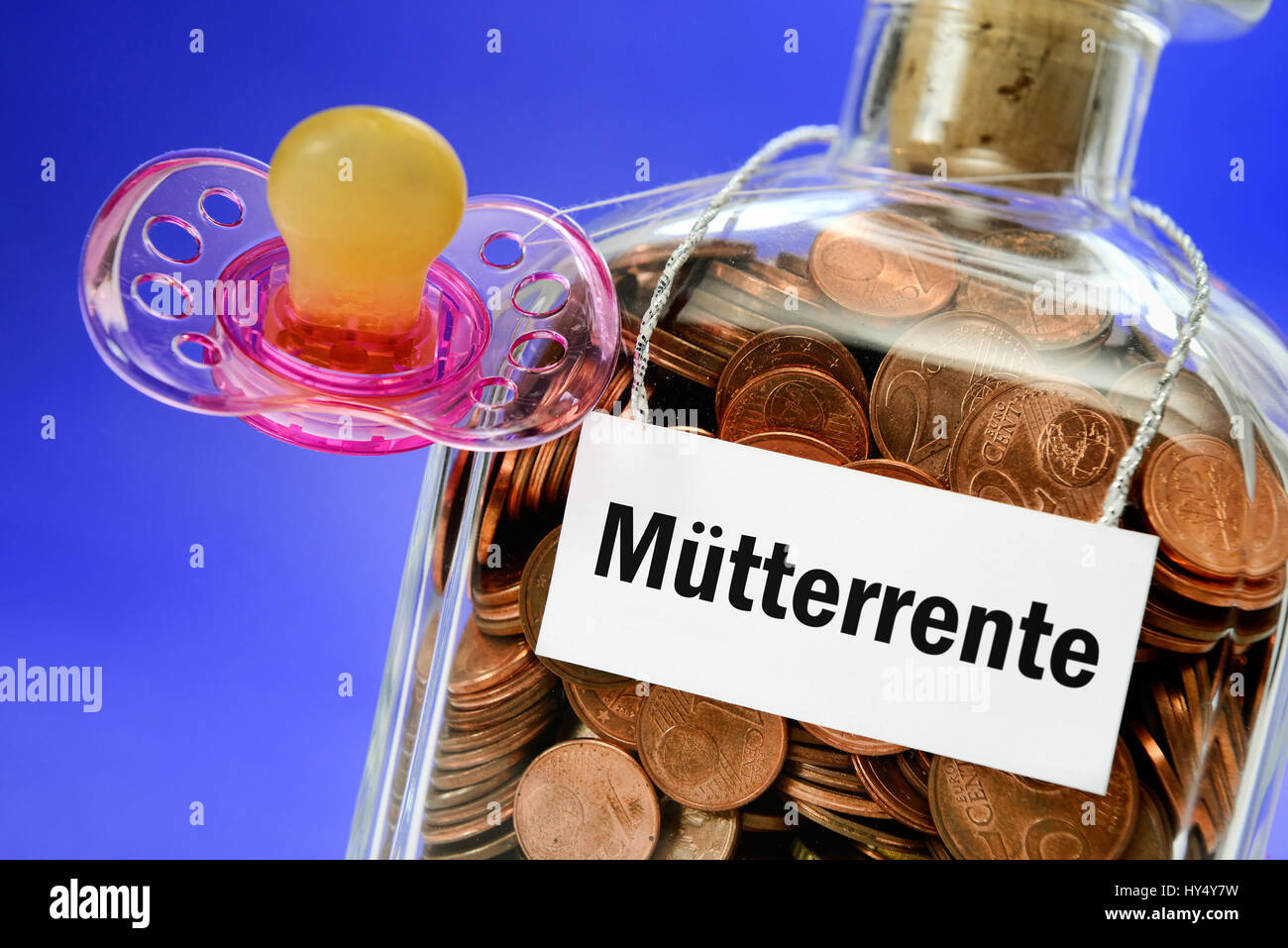 Bottle with monetary coins and dummy, symbolic photo mother's pension, Flasche mit Geldmuenzen und Schnuller, Symbolfoto Muetterrente Stock Photo