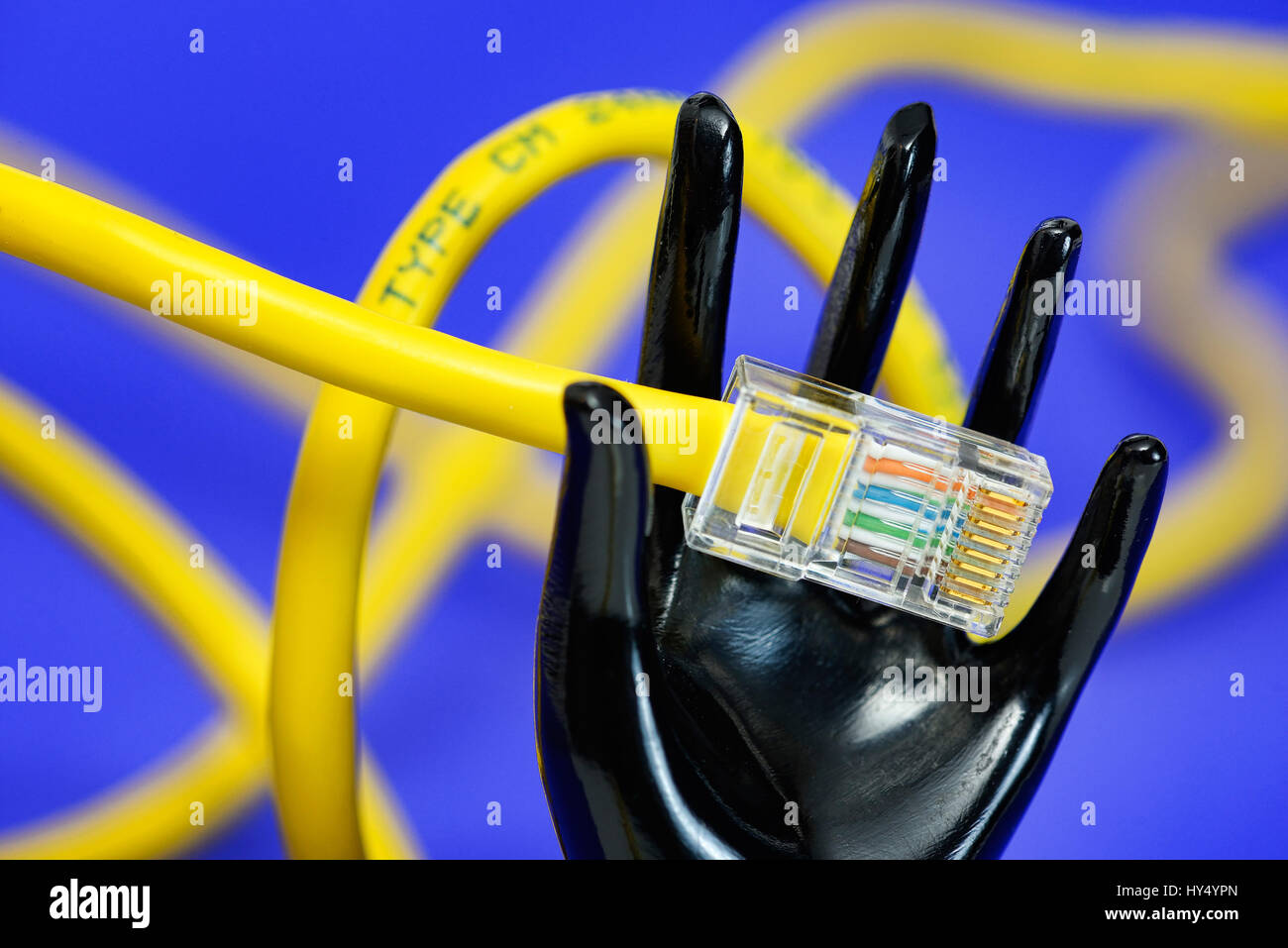 Black hand holds Internet cable, symbolic photo for the abolition of the net neutrality, Schwarze Hand haelt Internetkabel, Symbolfoto fuer die Aufheb Stock Photo