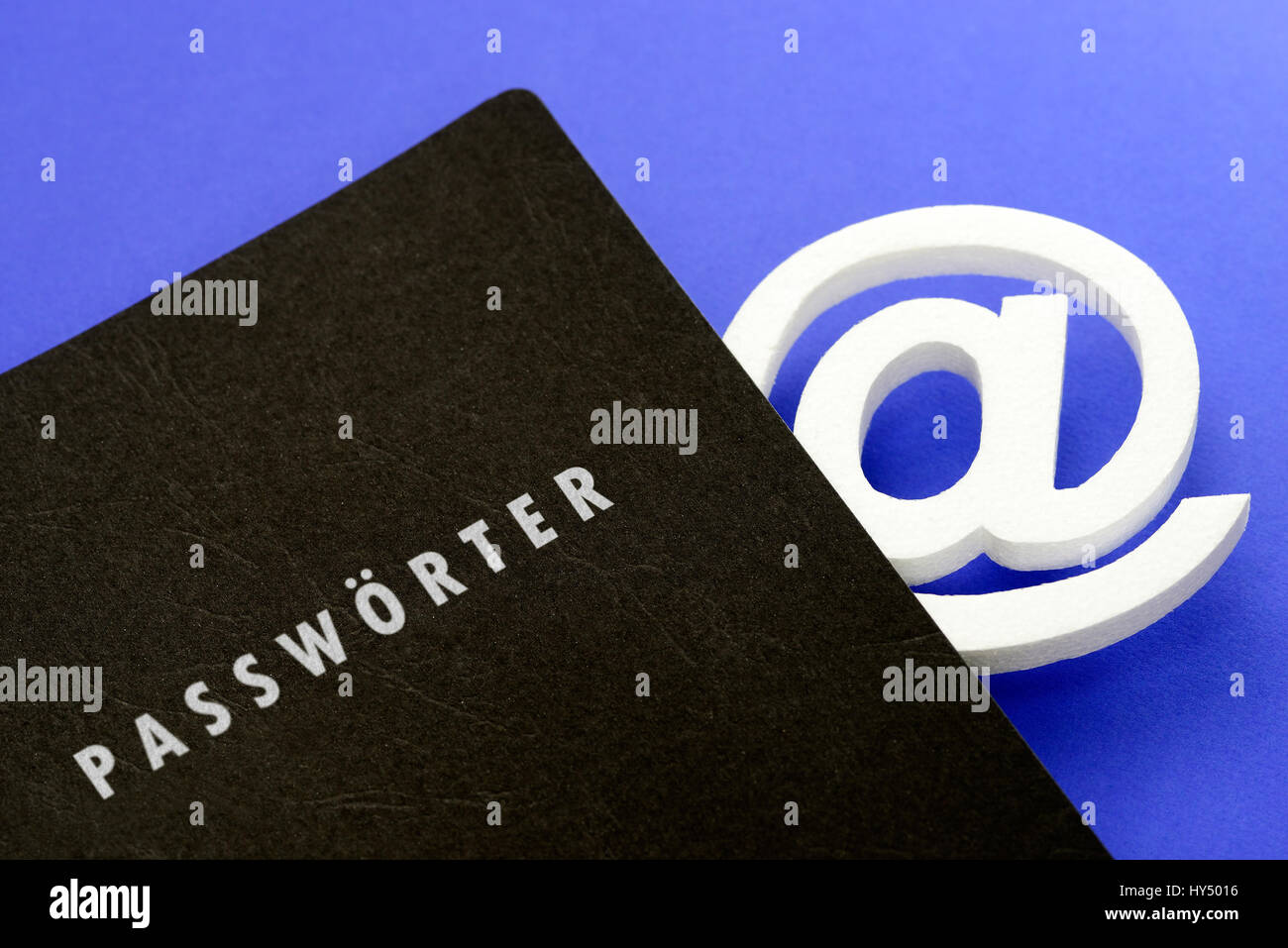 Atsign in black briefcase with label Passwords, Data theft, AtZeichen in schwarzer Mappe mit