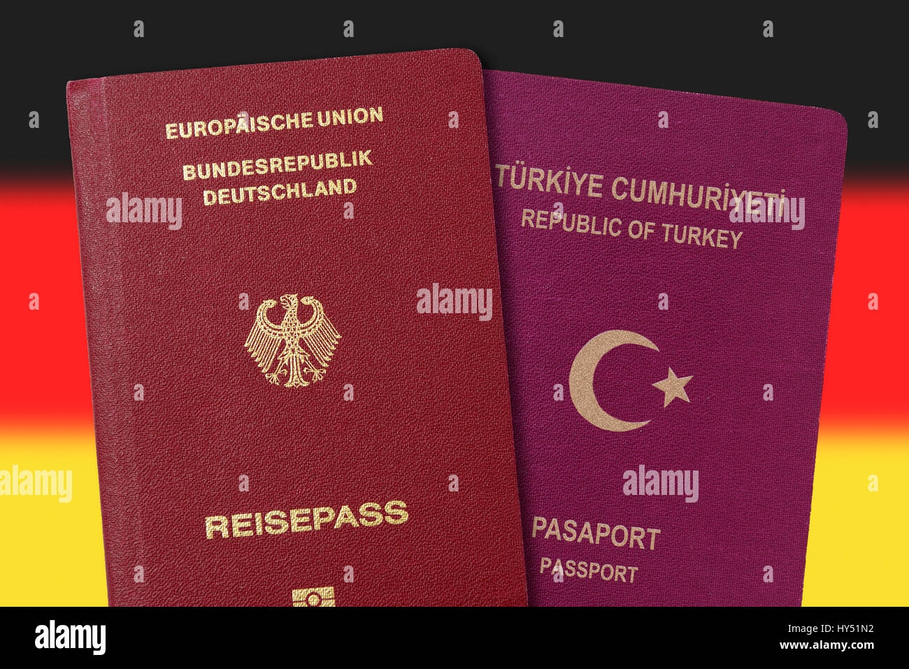 German and Turkish passport before Germany flag, double citizenship, Deutscher und tuerkischer Pass vor Deutschlandfahne, doppelte Staatsbuergerschaft Stock Photo
