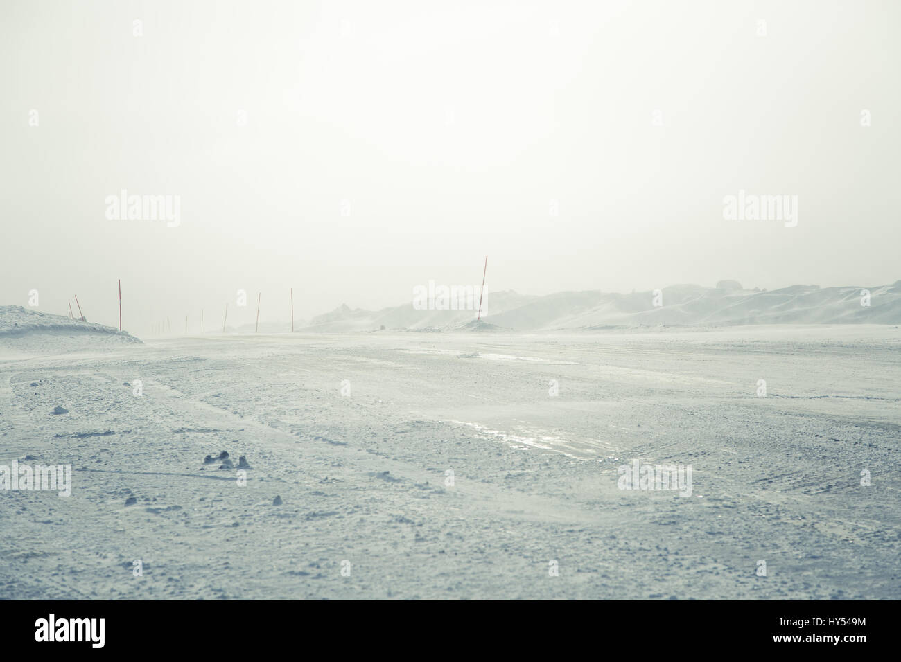 A beautiful landscape with a white, snowy road with safety poles in the Norwegian winter Stock Photo