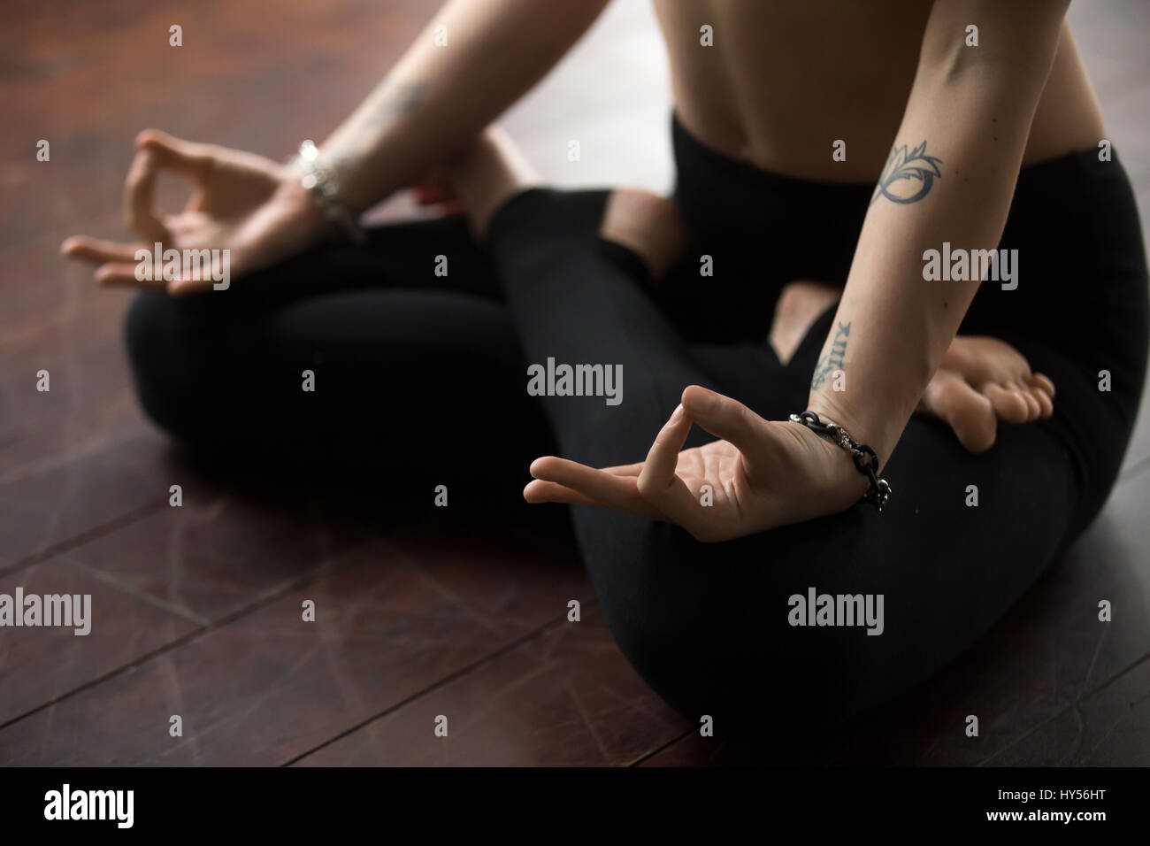 Woman sitting on floor in Lotus pose, making mudra gesture Stock Photo ...