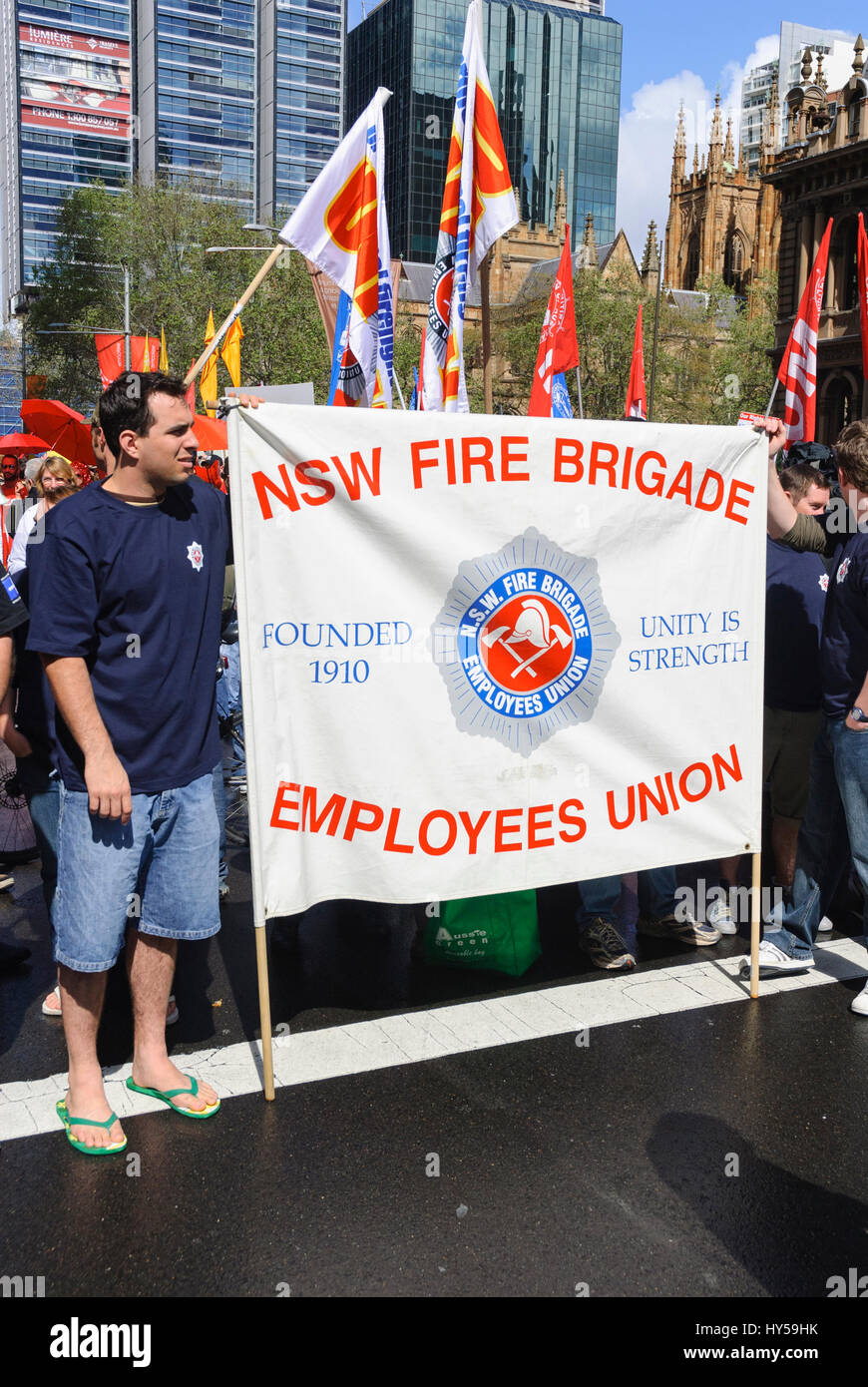 Off-duty firefighters hold the banner of their trade union banner during a protest. Trade unionism; union activism; union movement; fire brigade Stock Photo