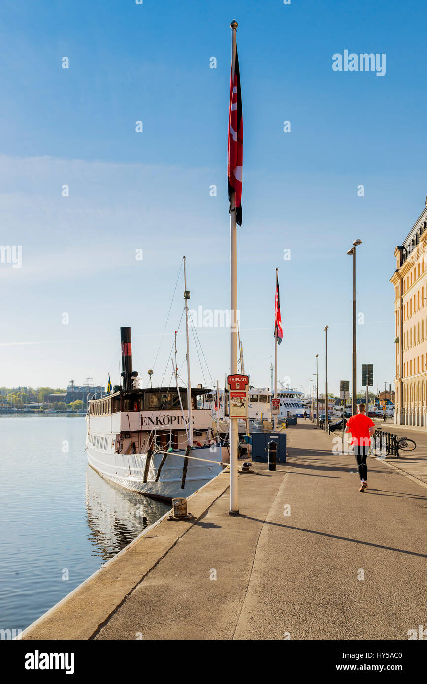 Sweden, Stockholm, Nybroviken, Rear view of man running in harbor Stock Photo