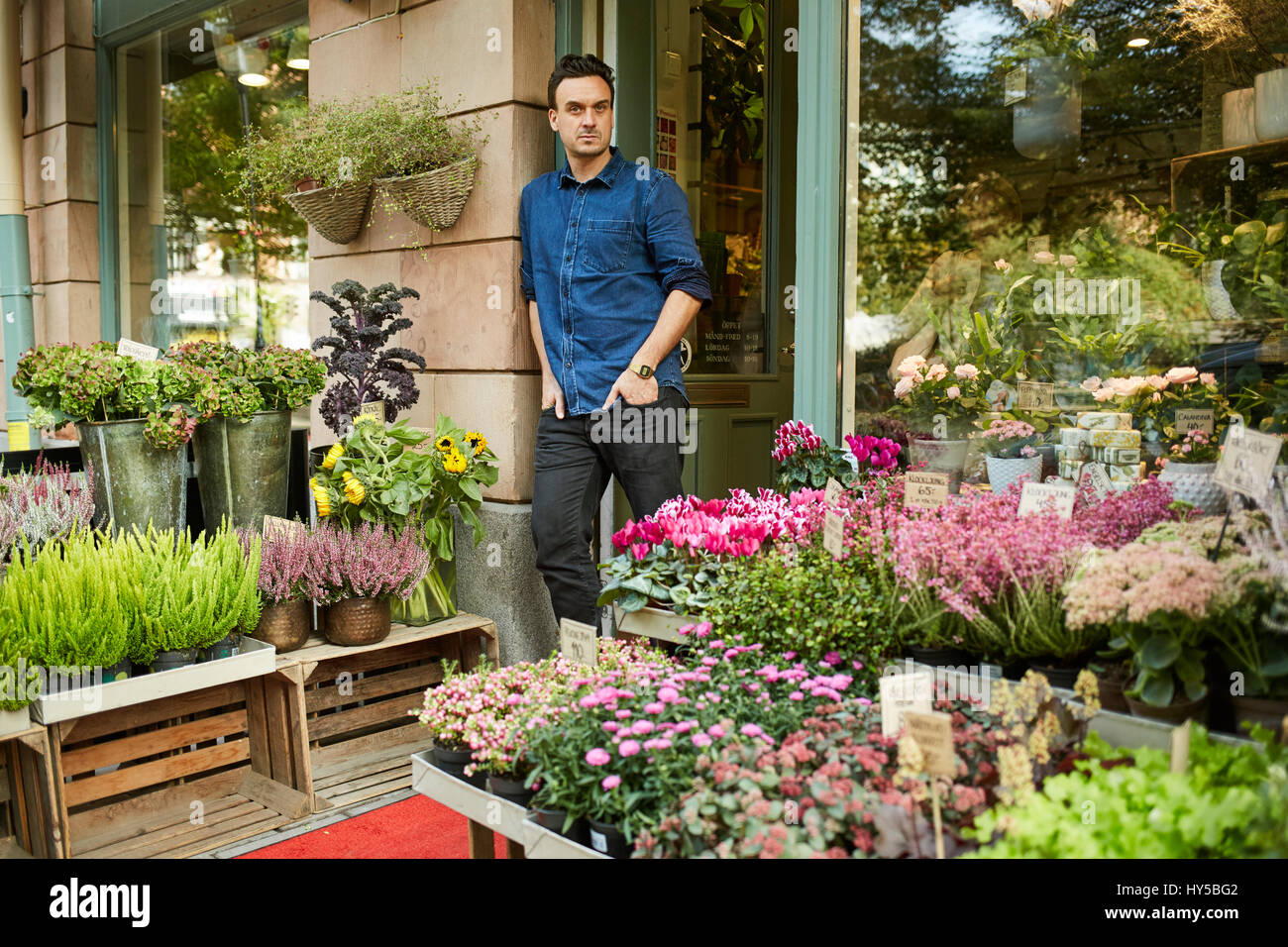 Sweden, Florist standing in front of entrance of flower shop Stock