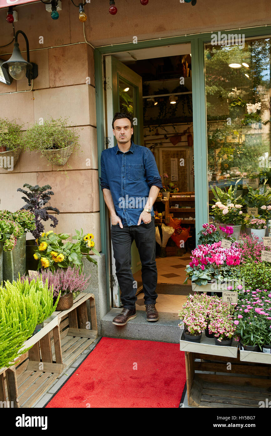 Sweden, Florist standing in front of entrance of flower shop Stock