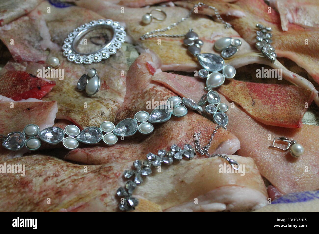 beautiful jewerly goods from pearl lay on fresh pink pork skin Stock Photo