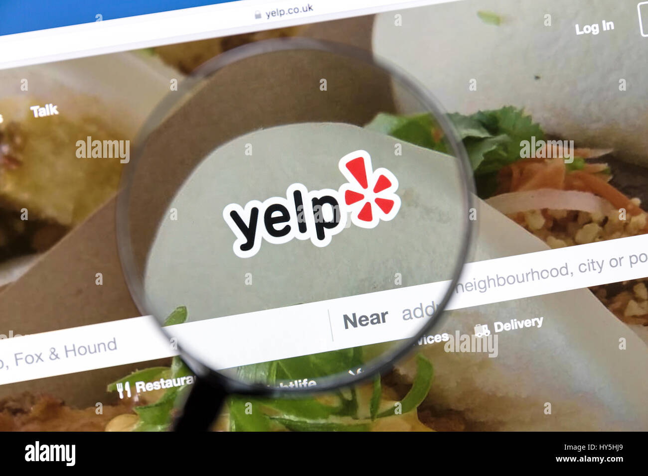 Yelp website under a magnifying glass Yelp is an American multinational corporation which publish crowd-sourced reviews about local businesses. Stock Photo