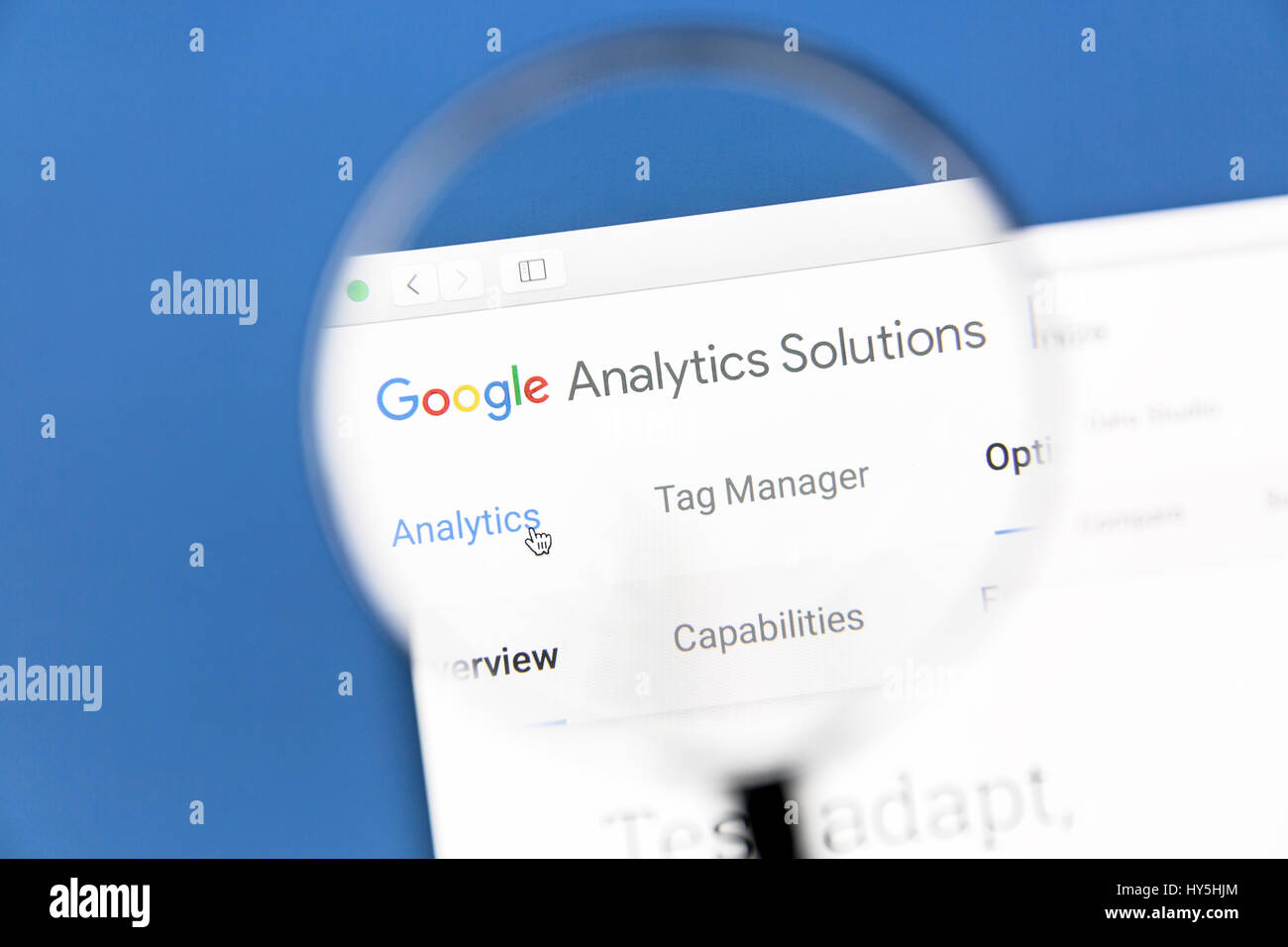 Google Analytics website under a magnifying glass. Google Analytics is a web analytics service offered by Google Stock Photo