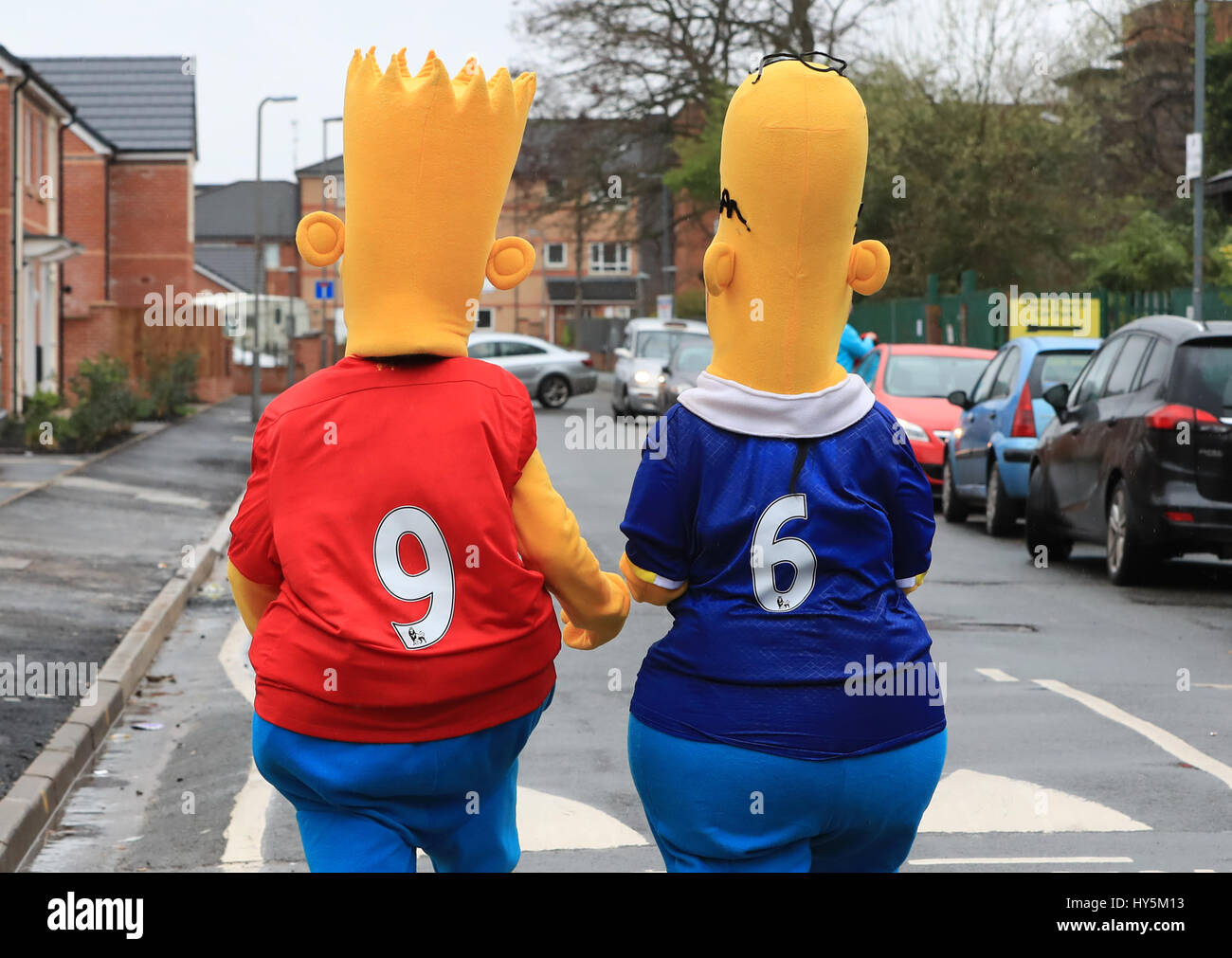 Fans dressed as Bart and Homer Simpson before the Premier League match at Anfield, Liverpool. Stock Photo