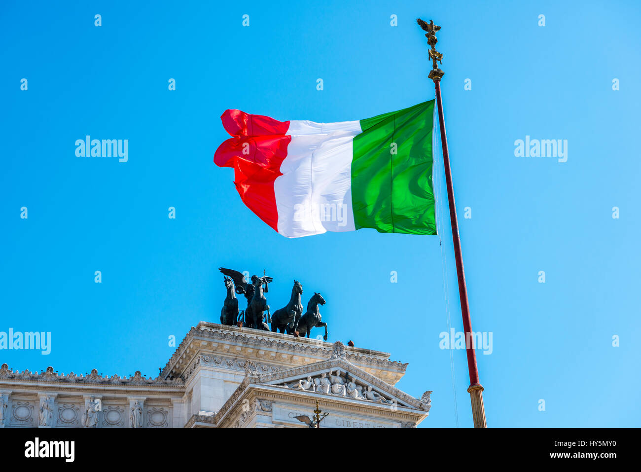 Italian flag drifting in front of Monumento Nazionale a Vittorio Emanuele II, Vittoriano, Altare della Patria, National Monument Stock Photo