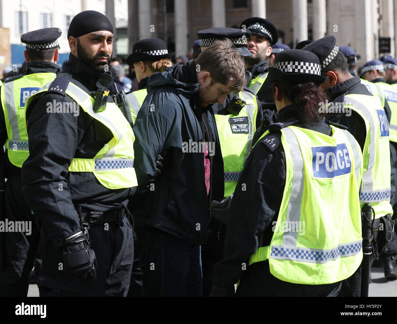 Police officers detain a UAF (Unite Against Fascism)demonstrator in ...