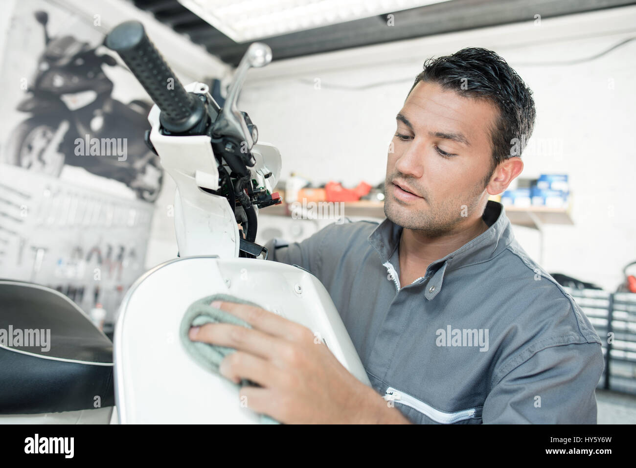 Mechanic cleaning a scooter Stock Photo Alamy