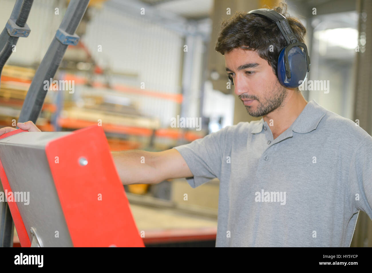 Man in factory wearing ear defenders Stock Photo Alamy