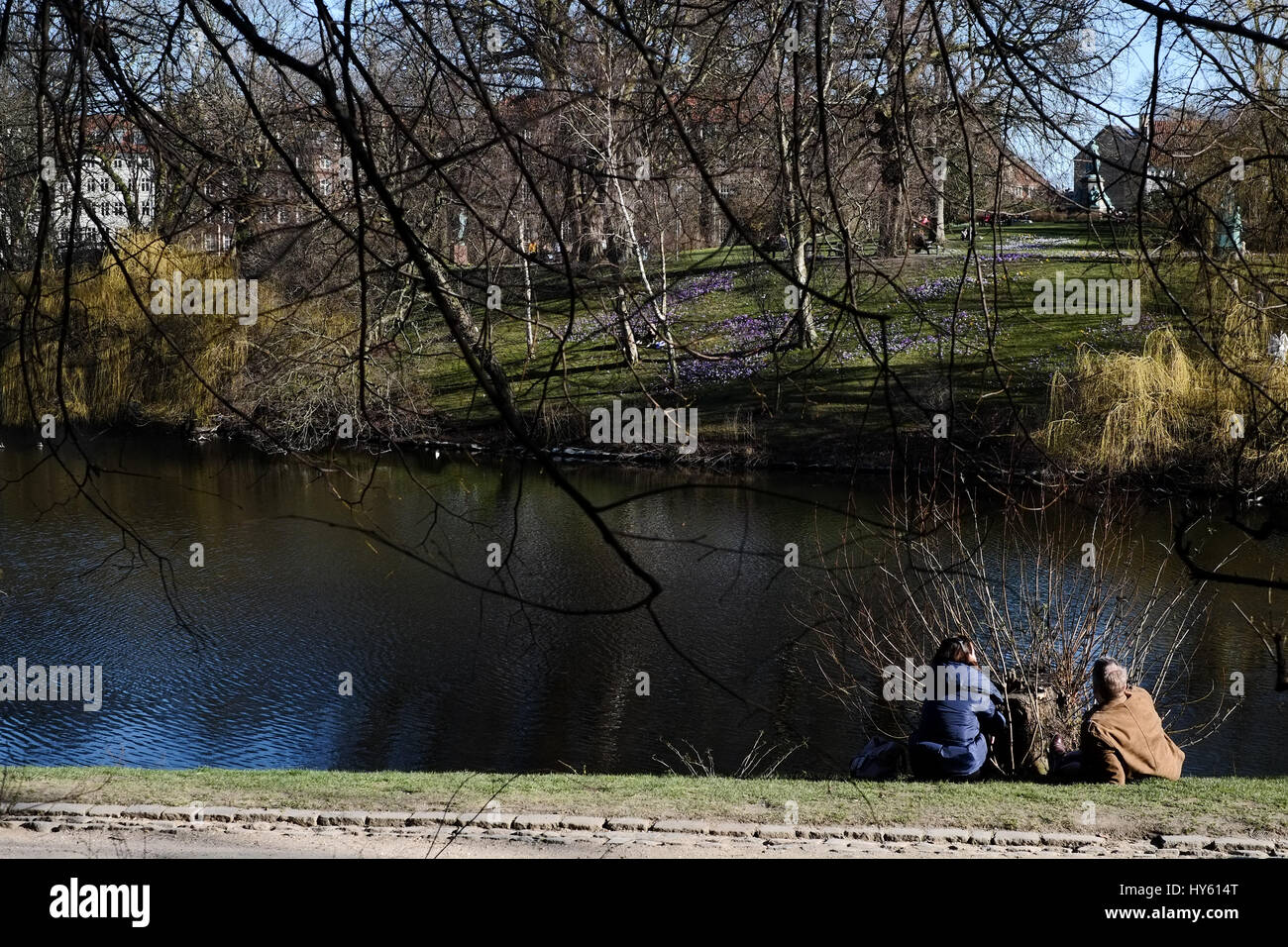 Visitors enjoying a strong spring sun at Ørstedsparken, a city centre park in Copenhagen, Denmark Stock Photo